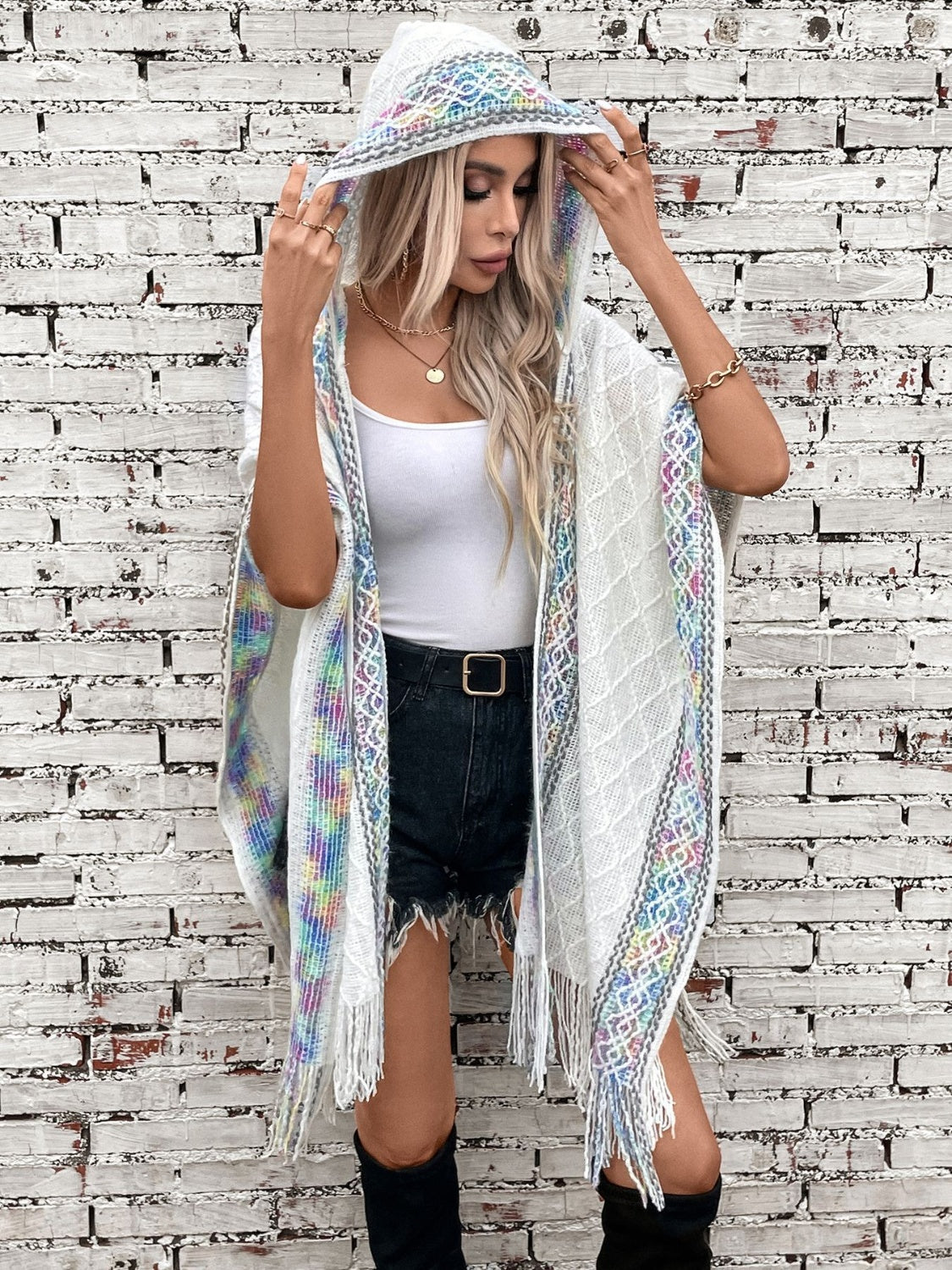 White knit hooded wrap with colorful embroidered trim and fringe detail.