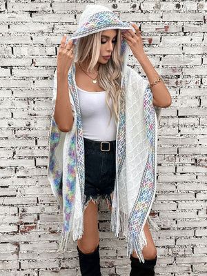 White knit hooded wrap with colorful embroidered trim and fringe detail.