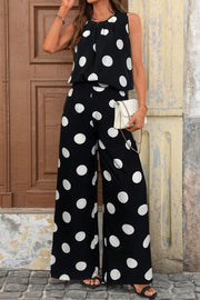 Black polka dot sleeveless top and wide-leg pants set with a white clutch.