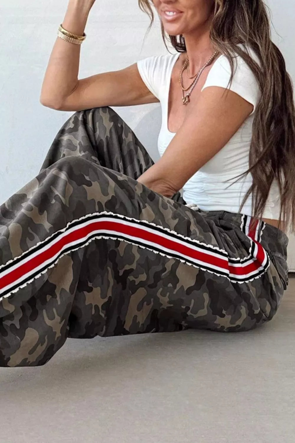 Camo print maternity pants with red, white, and black side stripe detail.
