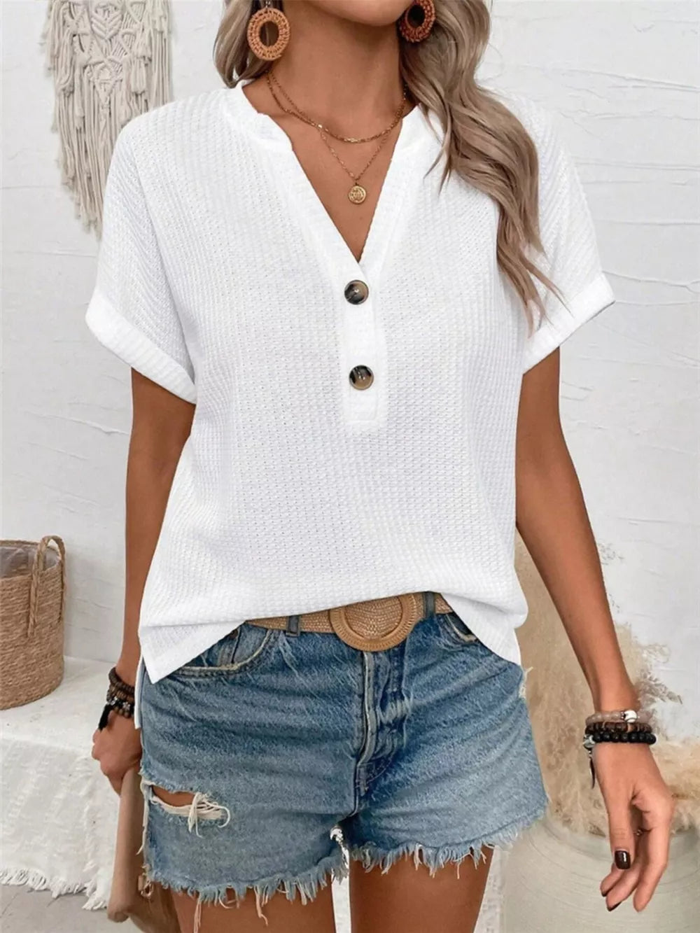 White waffle knit V-neck t-shirt with button detail and cuffed short sleeves.