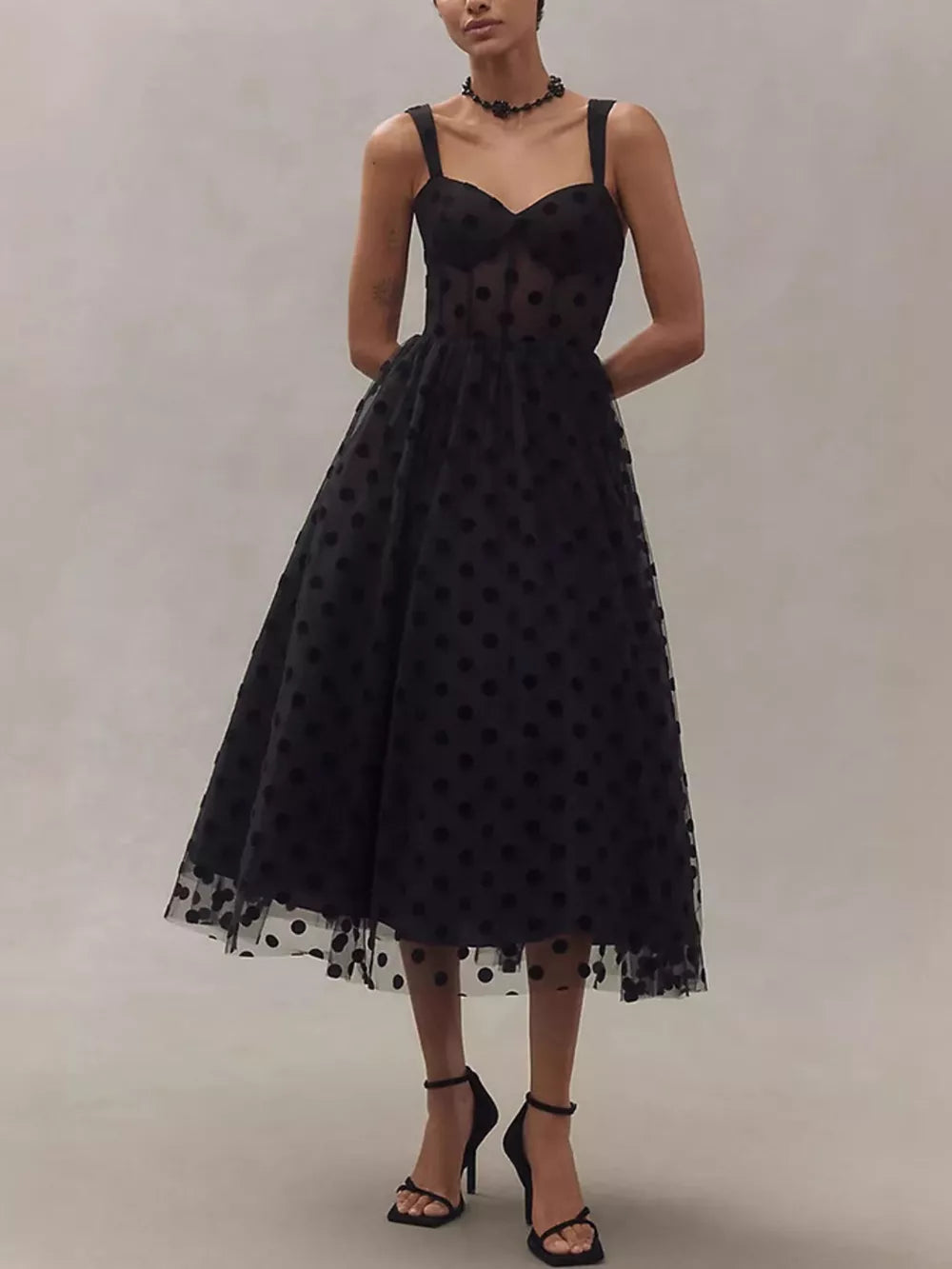 Black polka dot tulle dress with sweetheart neckline and midi skirt.