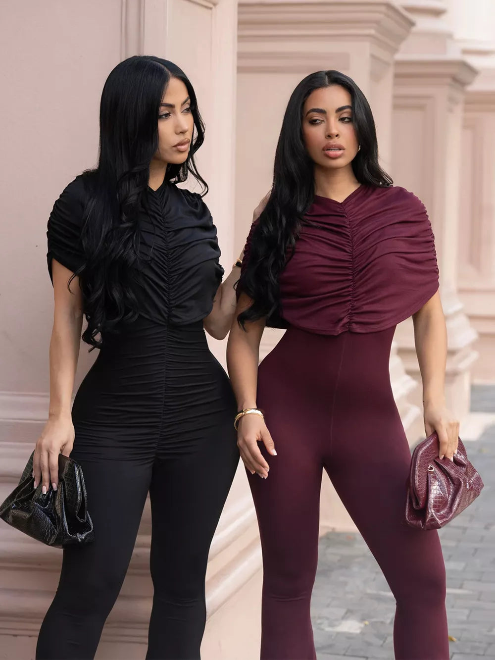 Black and burgundy ruched rompers with cap sleeves and flared legs.