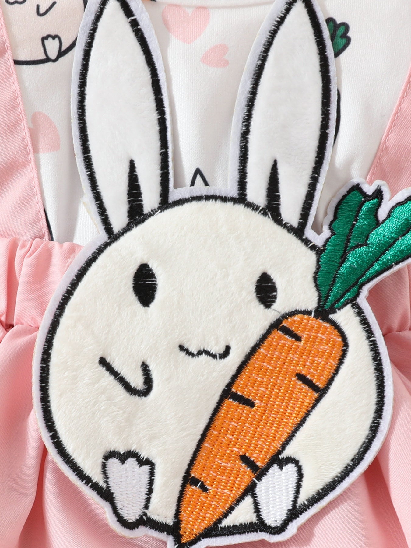 Baby dress with pink straps and white bodice featuring a fluffy bunny applique holding a carrot.