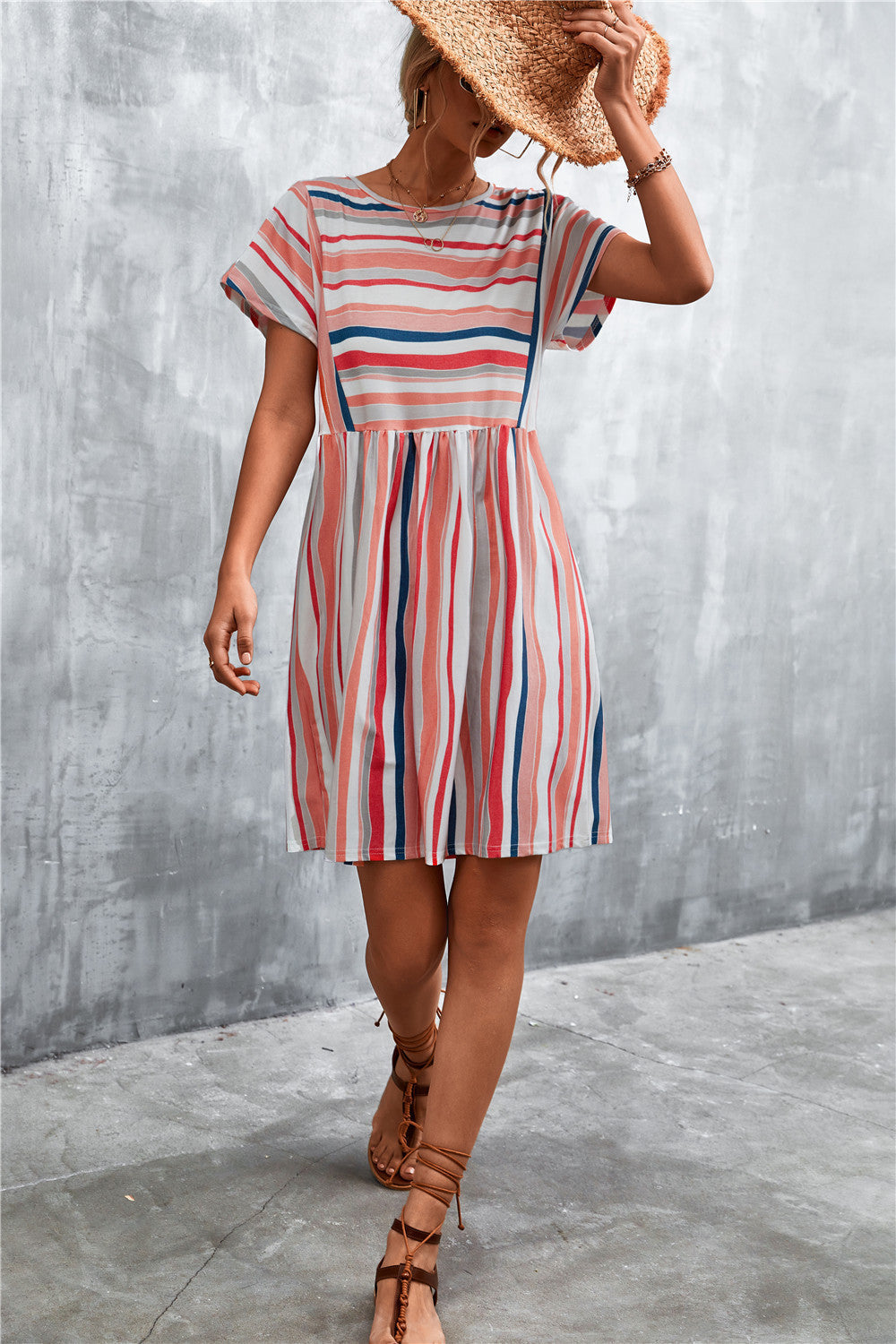 Striped yoke-seam trapeze dress with short sleeves and a gathered waist in coral, navy, and white stripes.