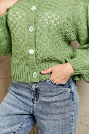 Green acrylic cropped cardigan with bubble sleeves and open knit detail