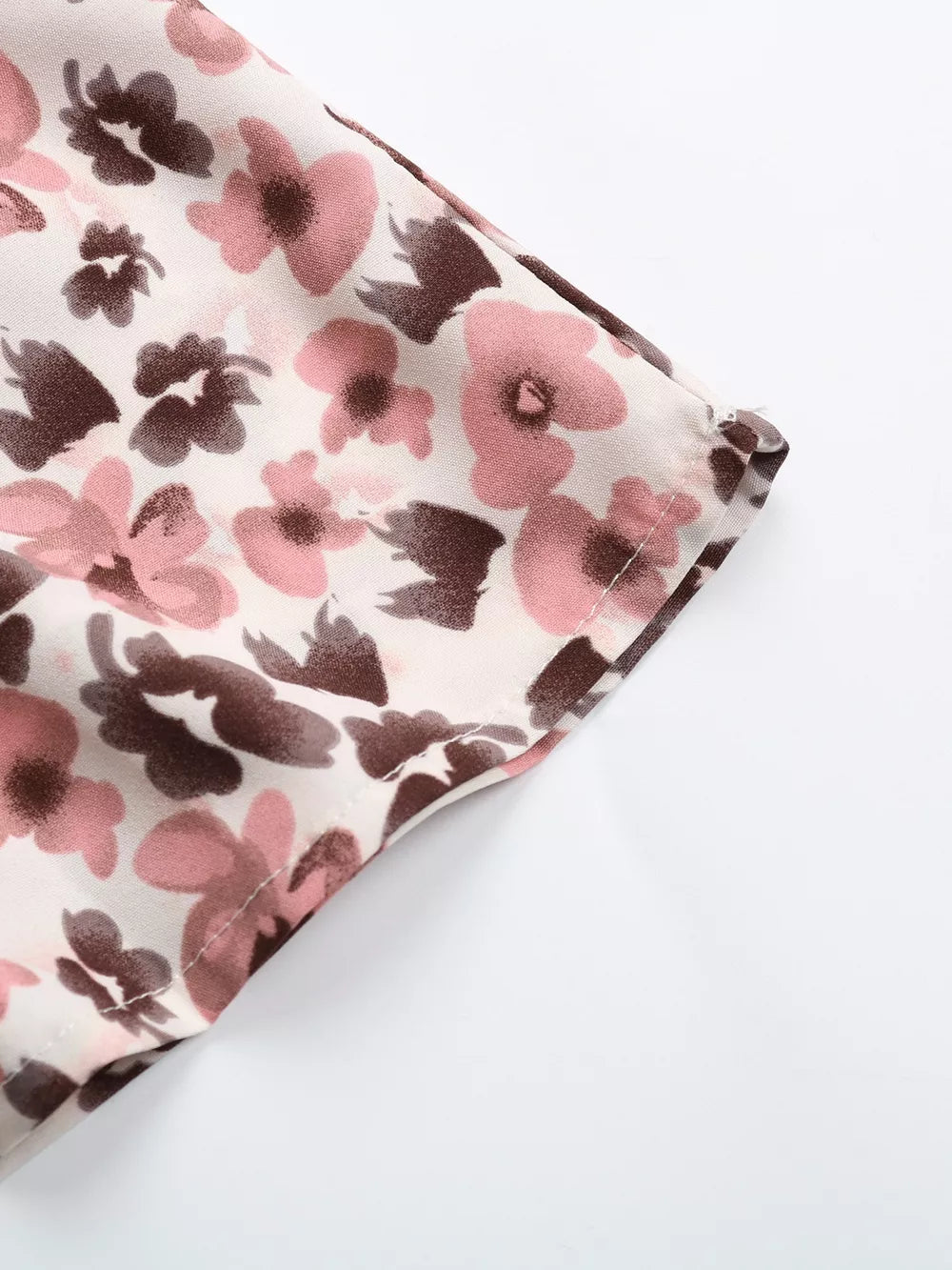 Charming floral tie-neck ruffle shirt with pink and brown abstract floral print on a light background.