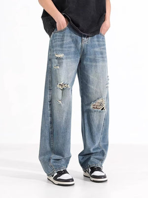 Men's distressed wide-leg jeans in washed blue denim with ripped details.