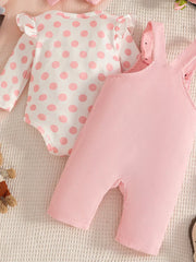 Pink corduroy overalls with a white polka dot bodysuit with ruffled sleeves and a pink bow headband.