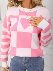 Blush pink and white checkerboard knit sweater with heart detail and striped sleeves.