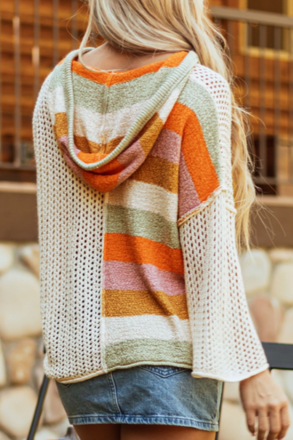 Colorblock knit hoodie with striped pattern in orange, pink, and green on a beige crochet body.