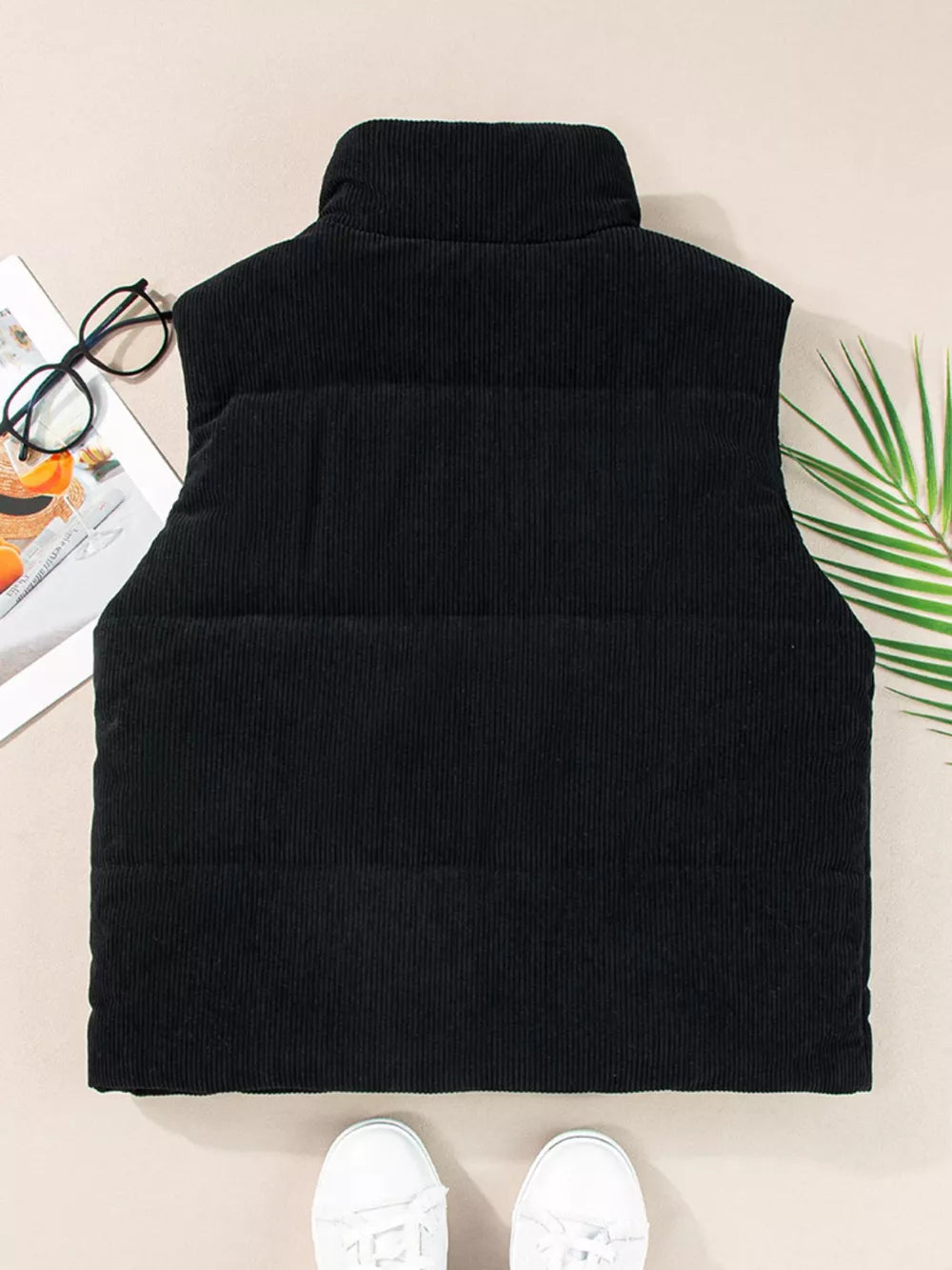 Black corduroy zip-up vest coat with a high neck and ribbed texture.