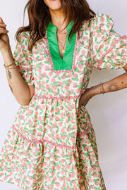 Women's tiered mini dress with pink floral print, green collar, and puff sleeves.