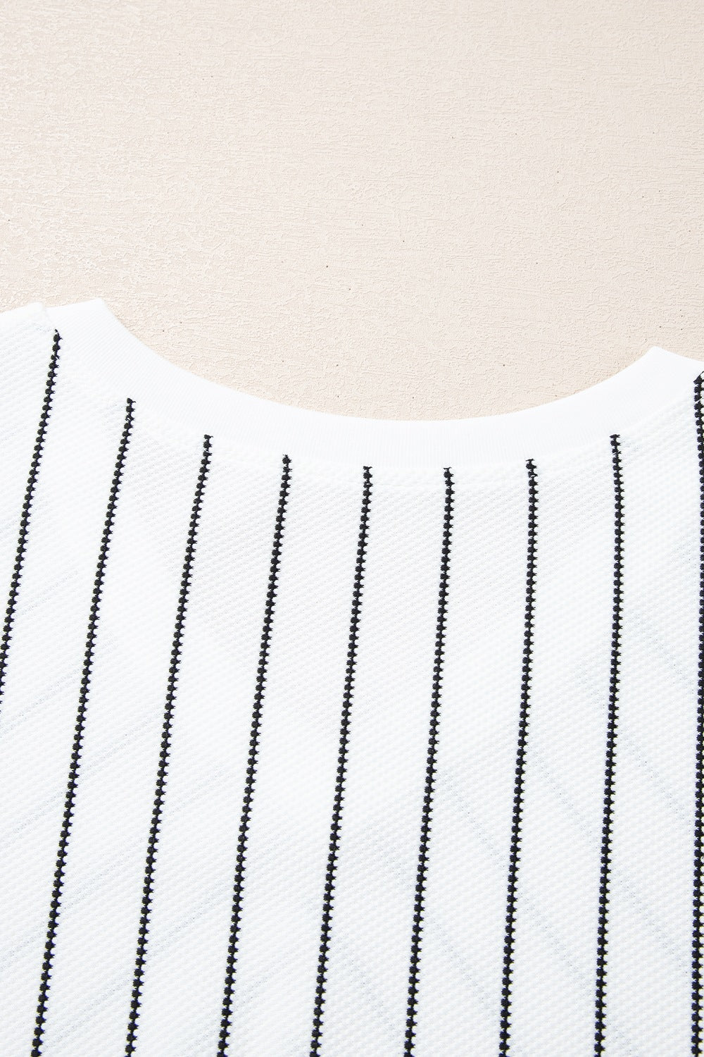 White relaxed fit blouse with black vertical pinstripes and a textured fabric.