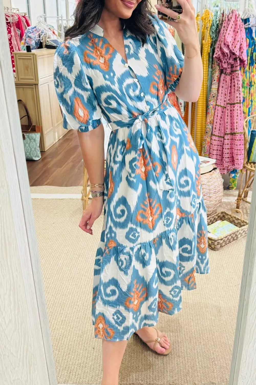 Ikat floral midi dress with puff sleeves, v-neck, tie waist, and tiered skirt.