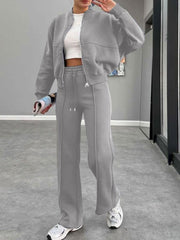 Gray bomber jacket and wide-leg tracksuit with drawstring waist and front zipper.