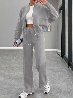 Gray bomber jacket and wide-leg tracksuit with drawstring waist and front zipper.