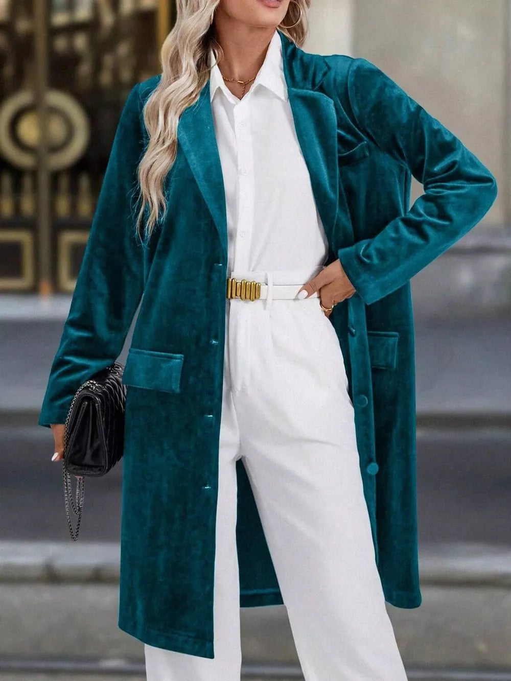 Elegant longline trench coat in deep teal velvet with lapel collar and buttoned front.