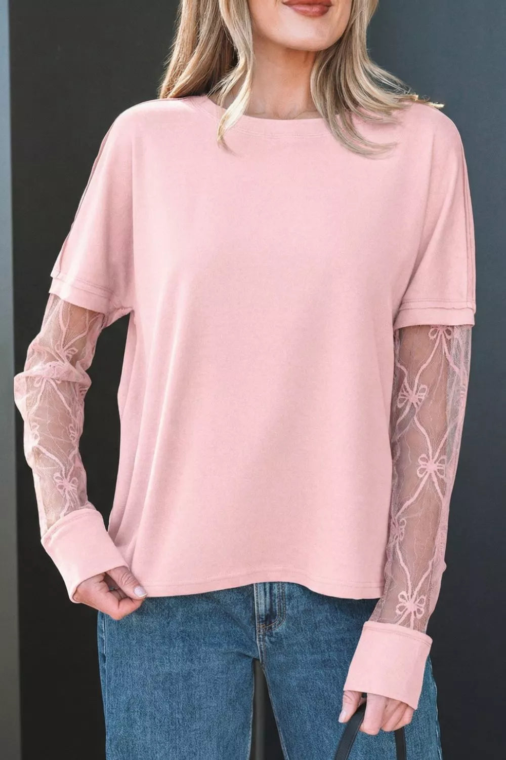 Pink maternity t-shirt with lace sleeves featuring bow details and crew neckline.