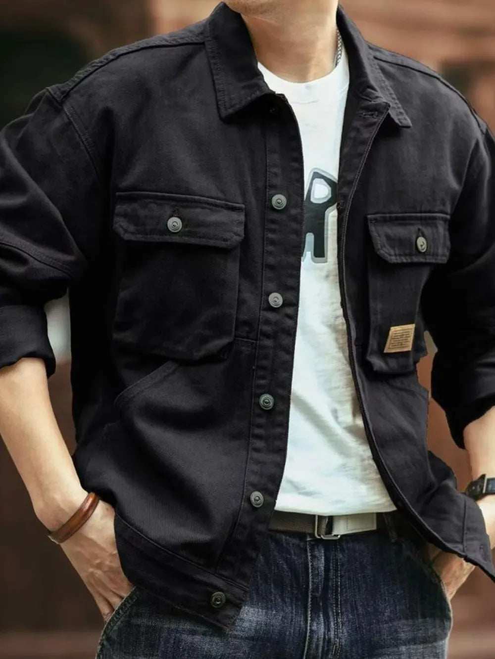 Black washed cotton chore jacket with four front pockets and button closure.