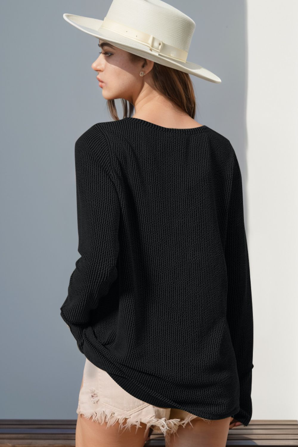 Black waffle knit henley shirt with thumbhole cuffs and a relaxed fit.
