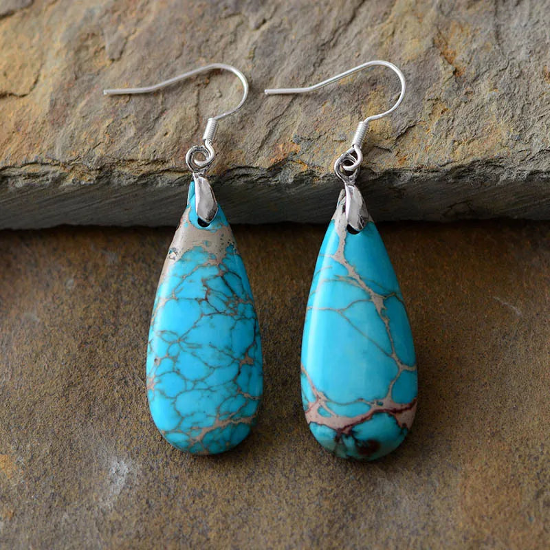 Turquoise vein teardrop dangle earrings with silver hooks.