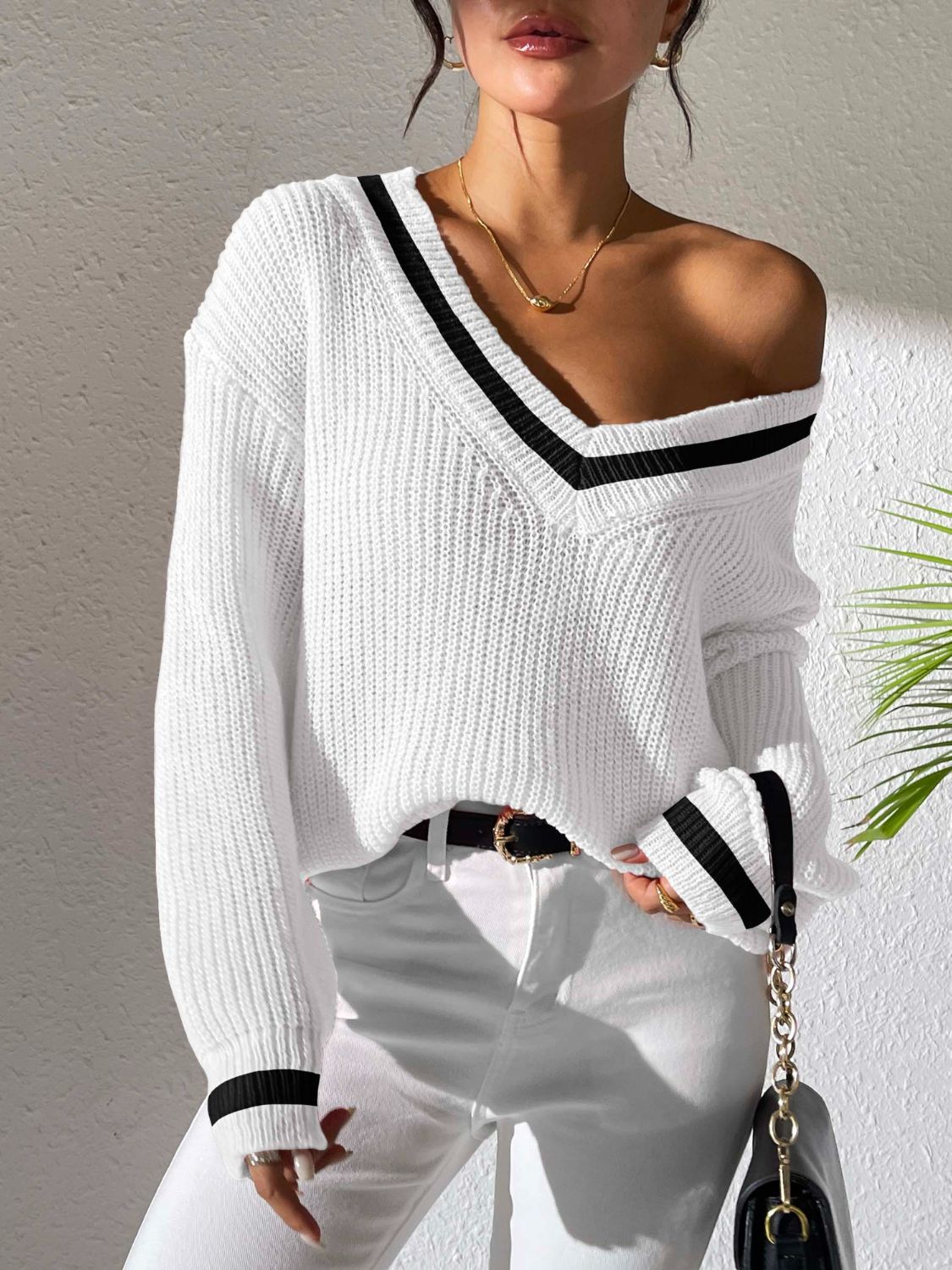 White ribbed knit sweater with varsity stripe V-neck and cuffs, styled off-shoulder.