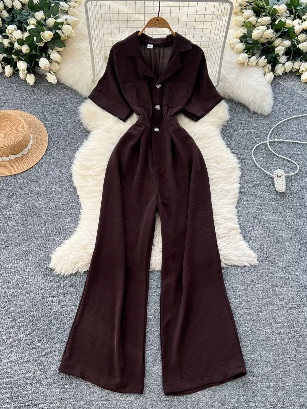 Brown belted wide-leg maternity jumpsuit with pockets and button front.
