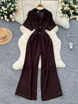 Brown belted wide-leg maternity jumpsuit with pockets and button front.
