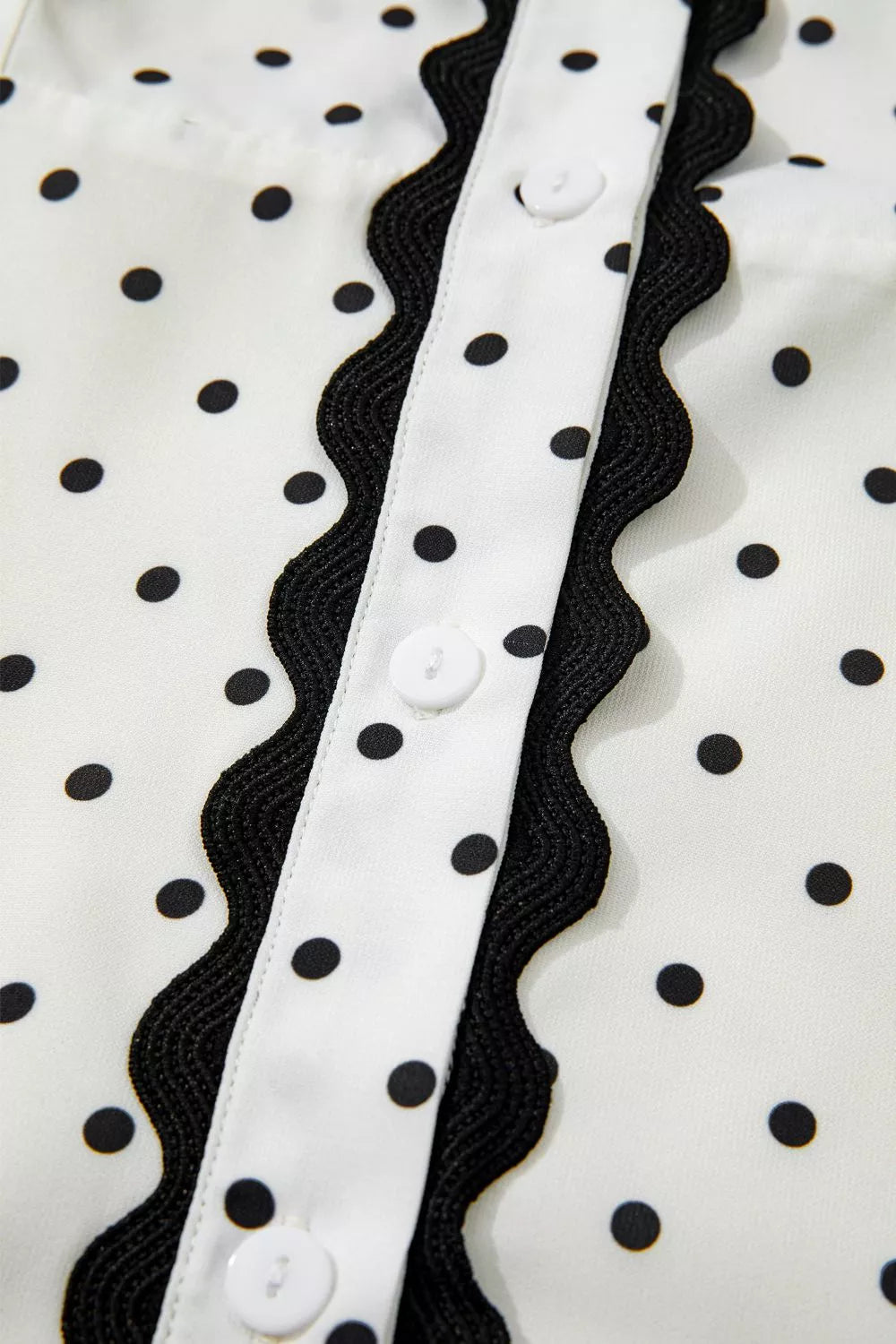 White polka dot midi dress with black scalloped trim and buttons