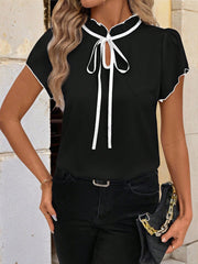 Black maternity blouse with white trim, tie-neck, and short sleeves.