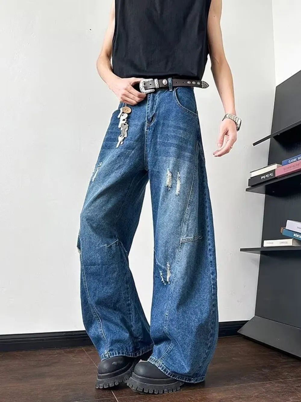 Distressed dark blue oversized wide-leg jeans with ankle length and a casual fit.