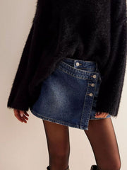 Denim skort in dark blue with asymmetrical button front and frayed hem.