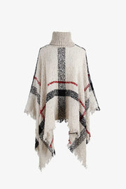 Beige plaid turtleneck cape with fringe detail and acrylic texture.