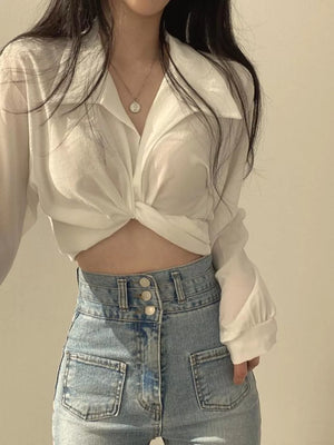White polyester long sleeve shirt with knotted front detail and buttoned cuffs.