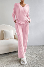 Wide-leg ribbed knit lounge set in carnation pink with V-neck sweater and relaxed fit pants.