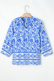 Blue ikat print V-neck blouse with border trim and 3/4 sleeves.