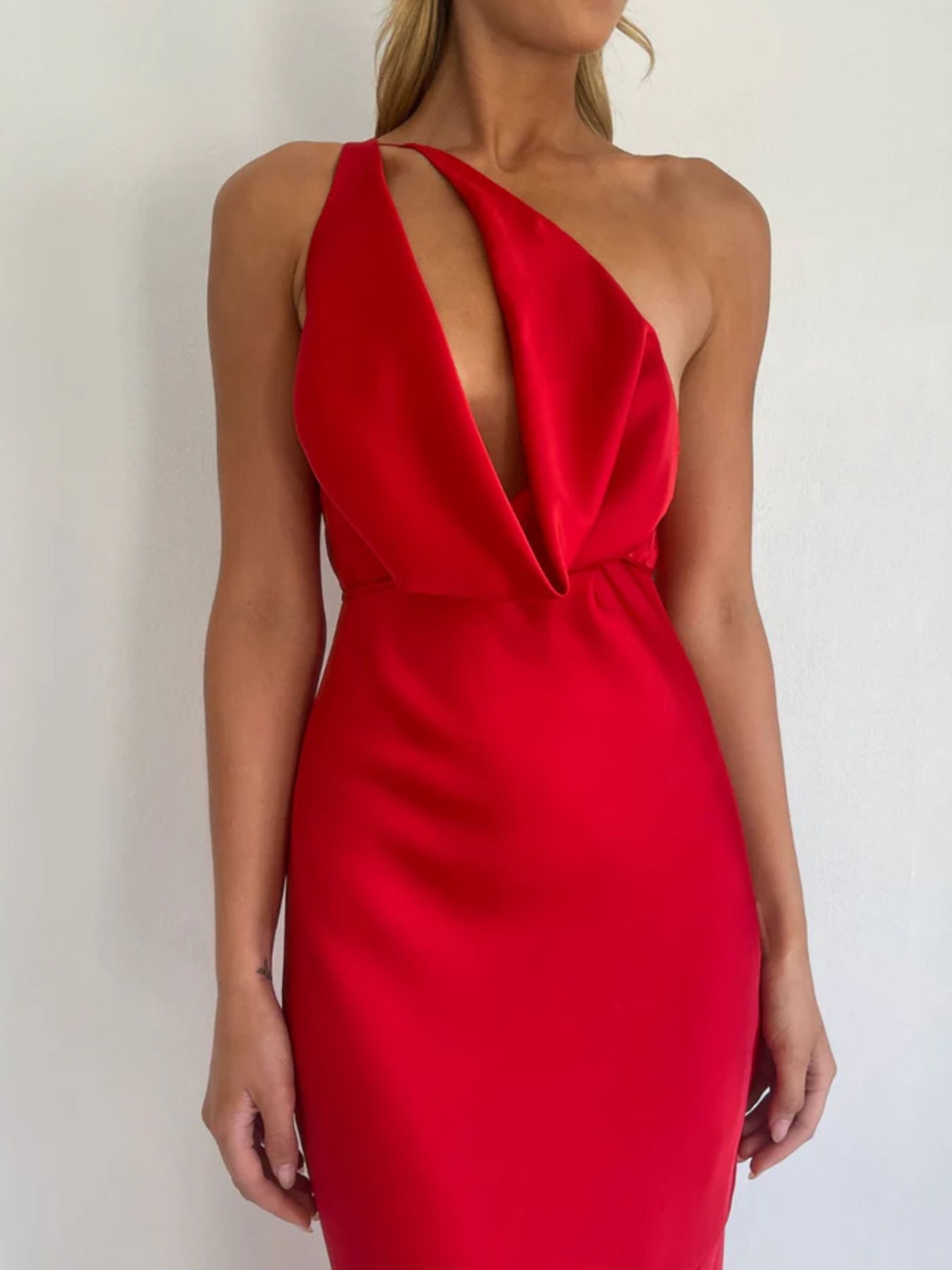 Red satin asymmetric halter maxi gown with a plunging neckline and body skimming fit.