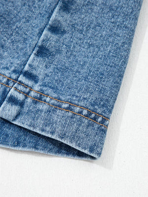 Belted denim dress detail showing stitching on blue cotton fabric.