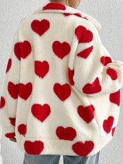 Cream sherpa zip-up jacket with all-over red heart print and collar.