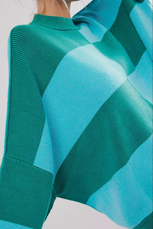 Checkerboard knit oversized sweater in turquoise and green with a mock neck and ribbed details.