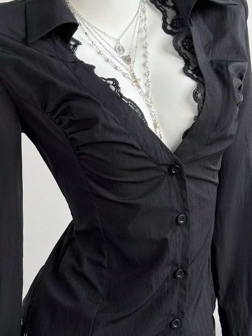Black lace-trimmed V-neck button-down shirt with ruched detailing.