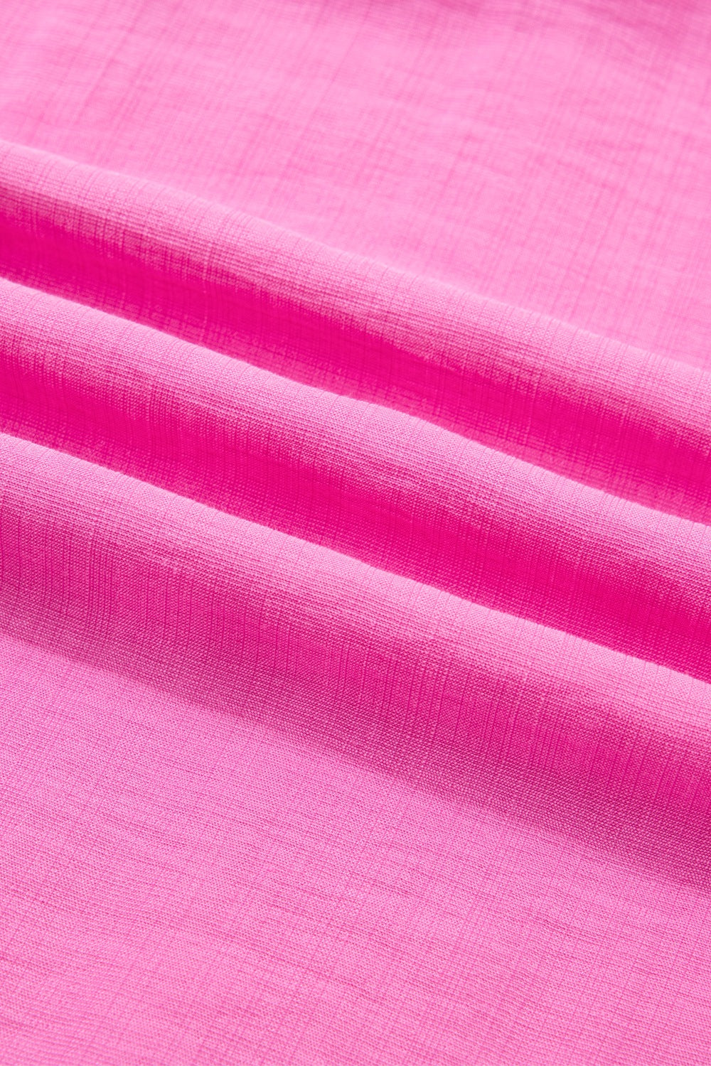 Ruffled sleeveless maxi dress in bright pink textured fabric with smocked waist detail.