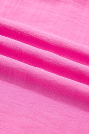 Ruffled sleeveless maxi dress in bright pink textured fabric with smocked waist detail.