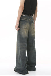Faded wash palazzo denim trousers in a medium blue with a wide leg and distressed details.