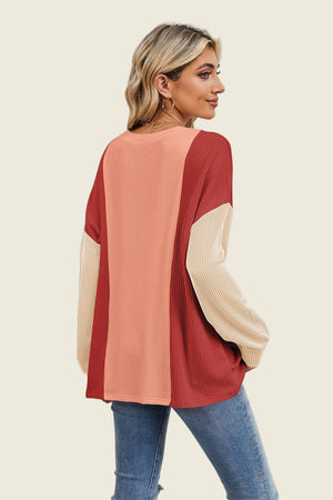 Colorblock waffle knit pullover sweater in red, coral, and tan with long sleeves.