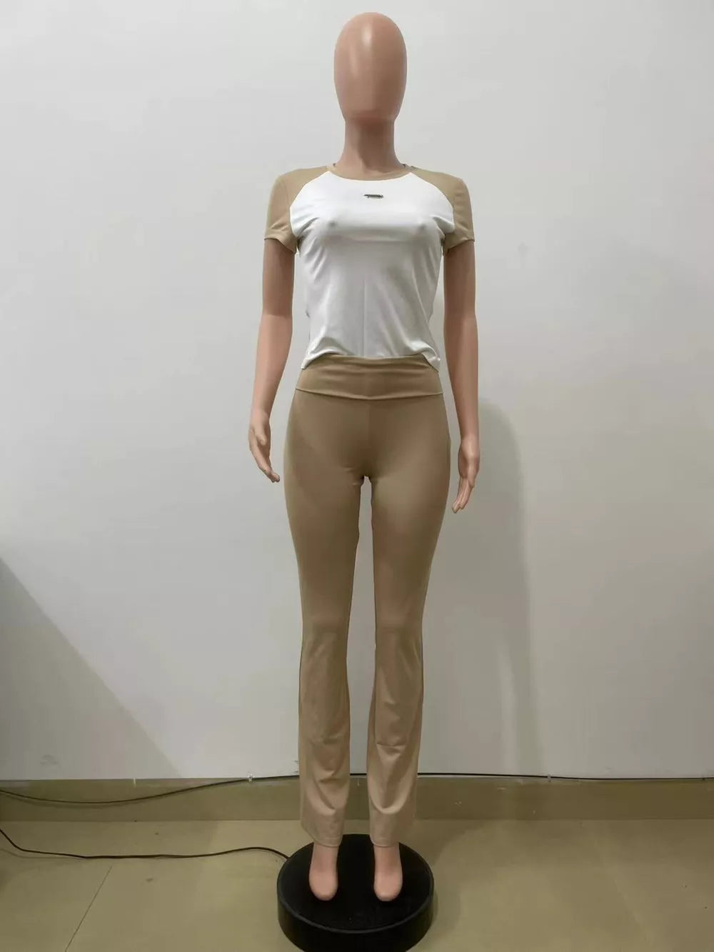 Chic contrast two-piece set with white tee and camel pants, body-hugging casual style.