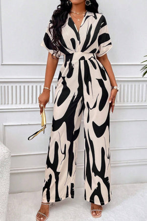 Abstract brushstroke wide-leg jumpsuit in black and taupe with short sleeves and a V-neck.