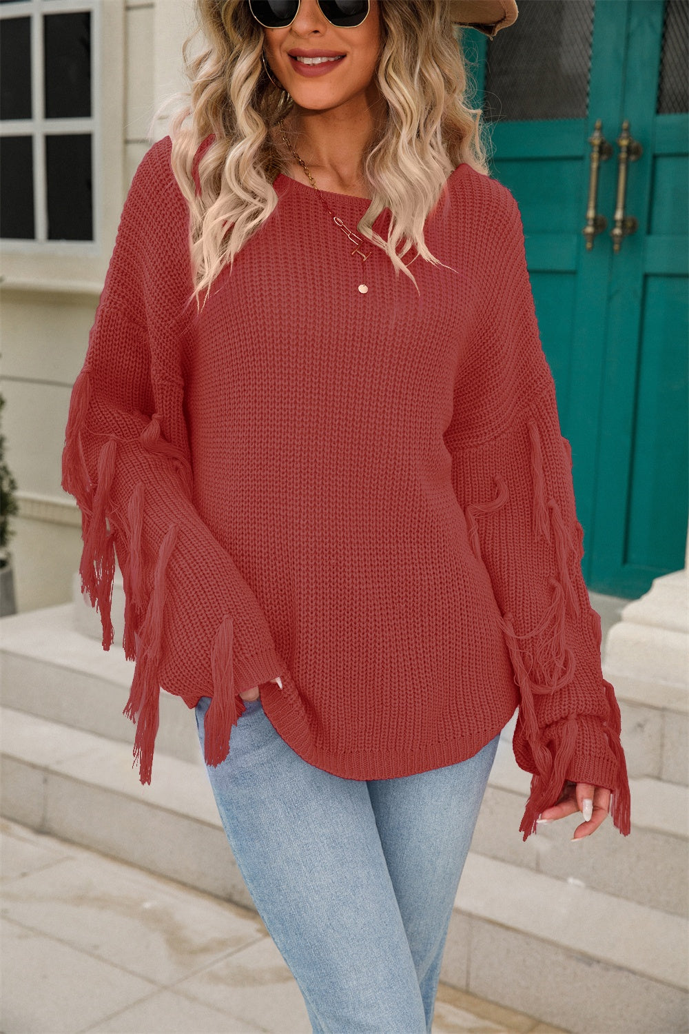 Rust acrylic knit sweater with fringe sleeves and a round neckline.