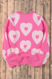 Fuchsia pink knit sweater with allover white heart motif and pearl embellishments on sleeves.